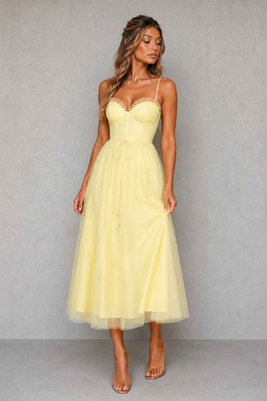 Woman wearing a yellow dress against a gray background