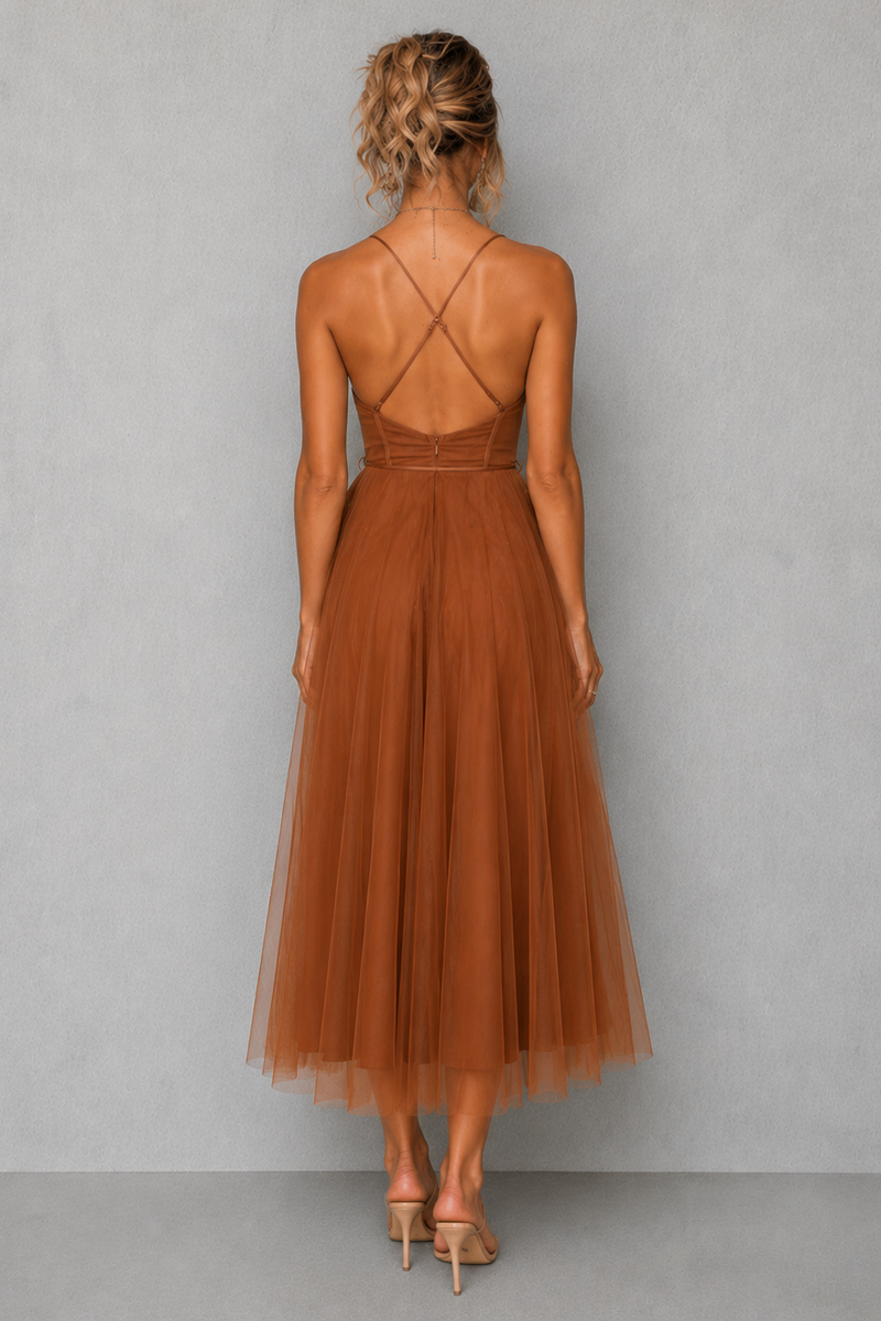 Woman wearing a brown dress with criss-cross back design on a gray background