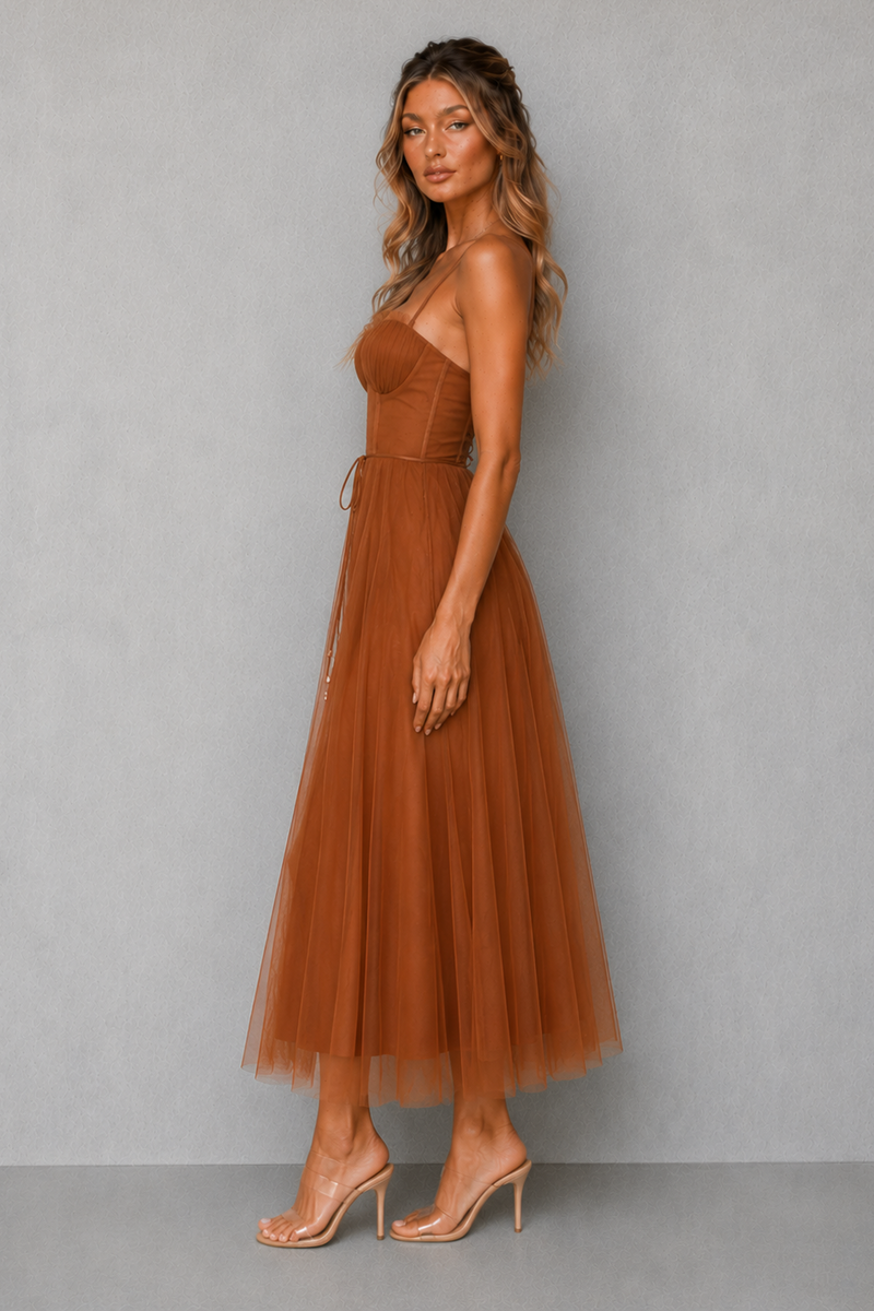Woman wearing a brown dress against a gray background