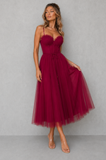 Woman wearing a burgundy dress against a gray background