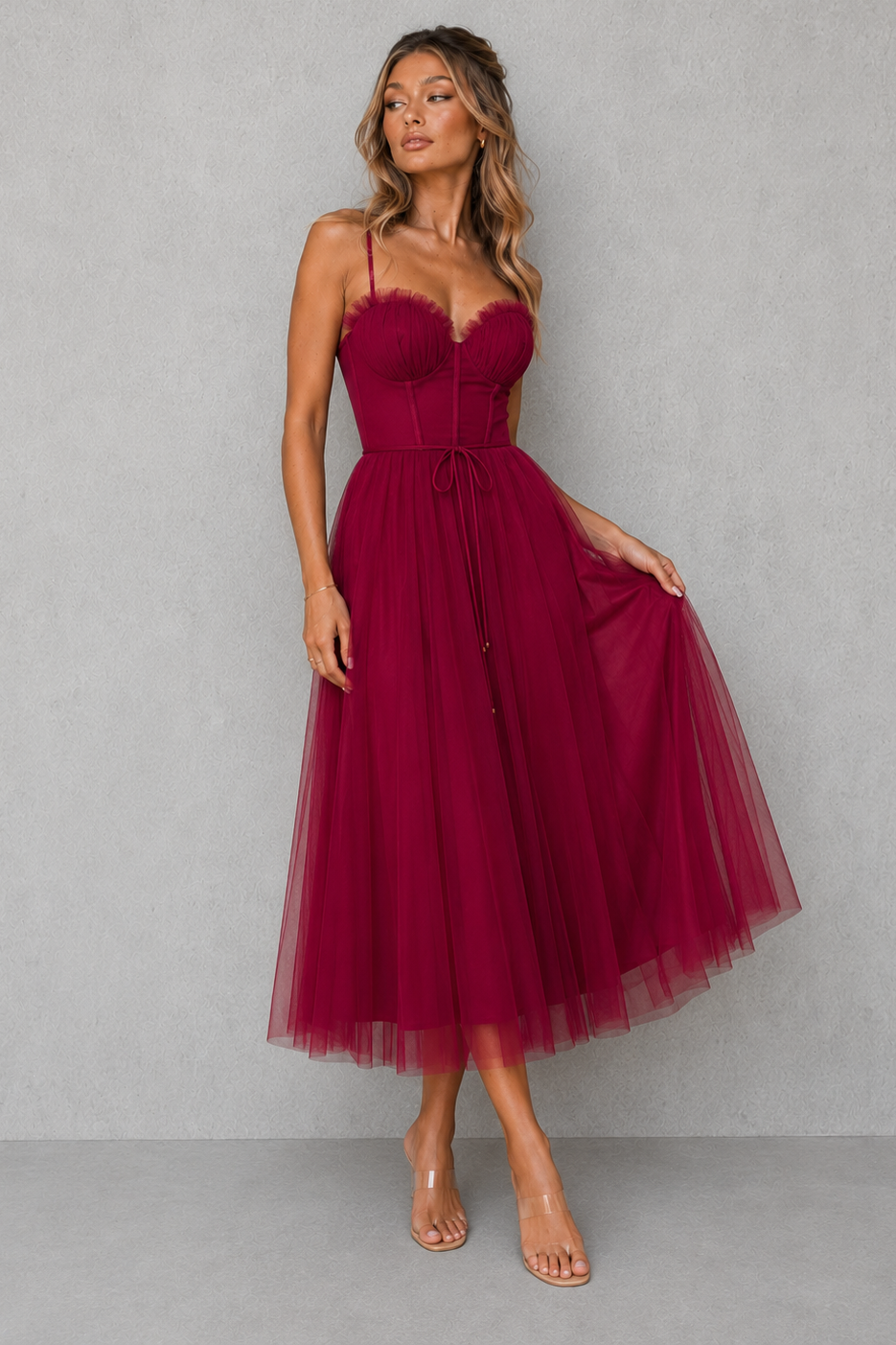 Woman wearing a burgundy dress against a gray background
