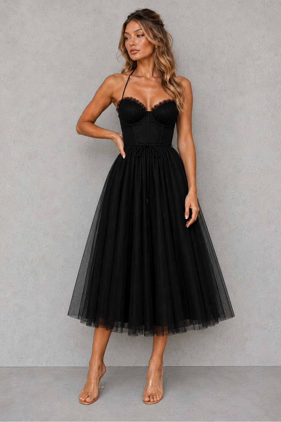 Woman wearing a black tulle dress against a gray background