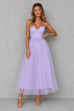 Woman wearing a lavender dress against a gray background