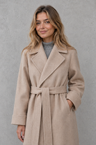 Women's elegant wrap coat in a longline design with a tailored lapel collar and adjustable matching waist belt, offering a flattering regular fit and lightweight warmth for autumn and winter wear.