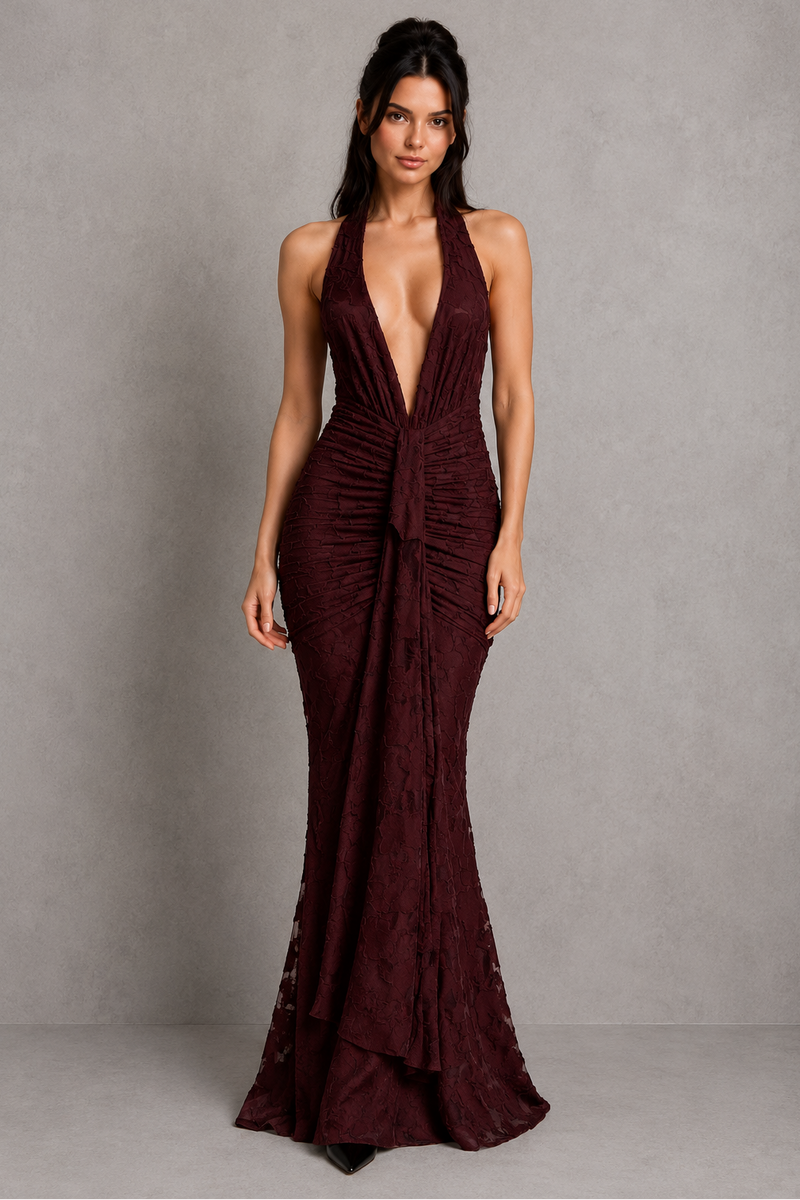 Woman wearing a burgundy evening gown against a gray background