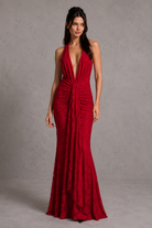 Woman wearing a red halter neck gown against a gray background