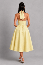 Yellow dress with a bow detail on a gray background