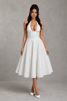 Woman wearing a white dress against a gray background