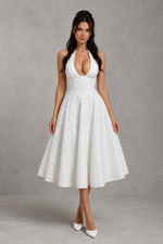 Woman wearing a white dress against a gray background