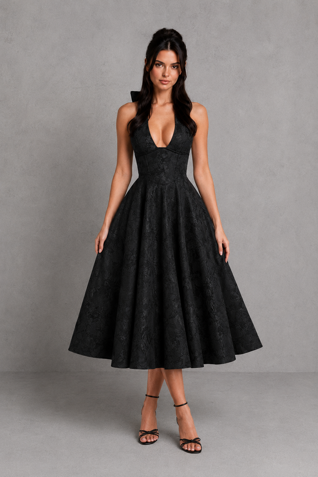Woman wearing a black dress against a gray background