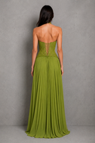 Woman wearing a green strapless gown against a gray background