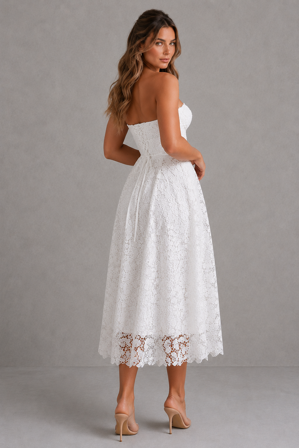 Woman wearing a white lace dress against a gray background