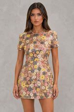 Woman wearing a floral dress against a gray background