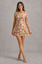 Woman wearing a floral dress against a gray background