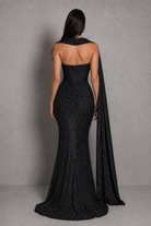 Black evening gown with cape on a gray background