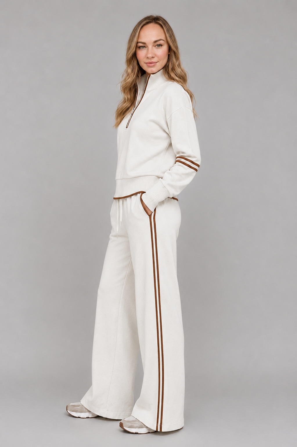 Women's half zip lounge set featuring a relaxed fit sweatshirt with a funnel neckline, contrast stripe detailing, and matching wide leg trousers with an elasticated drawstring waistband in soft stretch fabric.