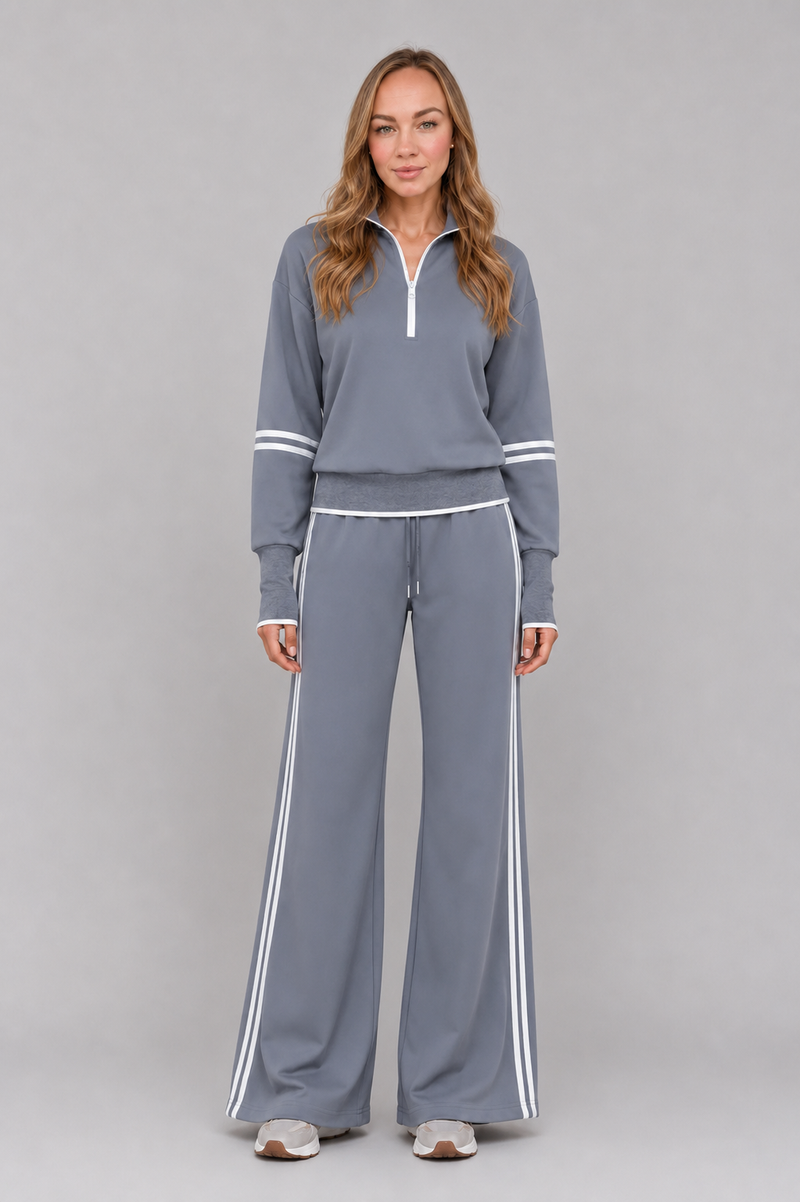 Women's half zip lounge set featuring a relaxed fit sweatshirt with a funnel neckline, contrast stripe detailing, and matching wide leg trousers with an elasticated drawstring waistband in soft stretch fabric.