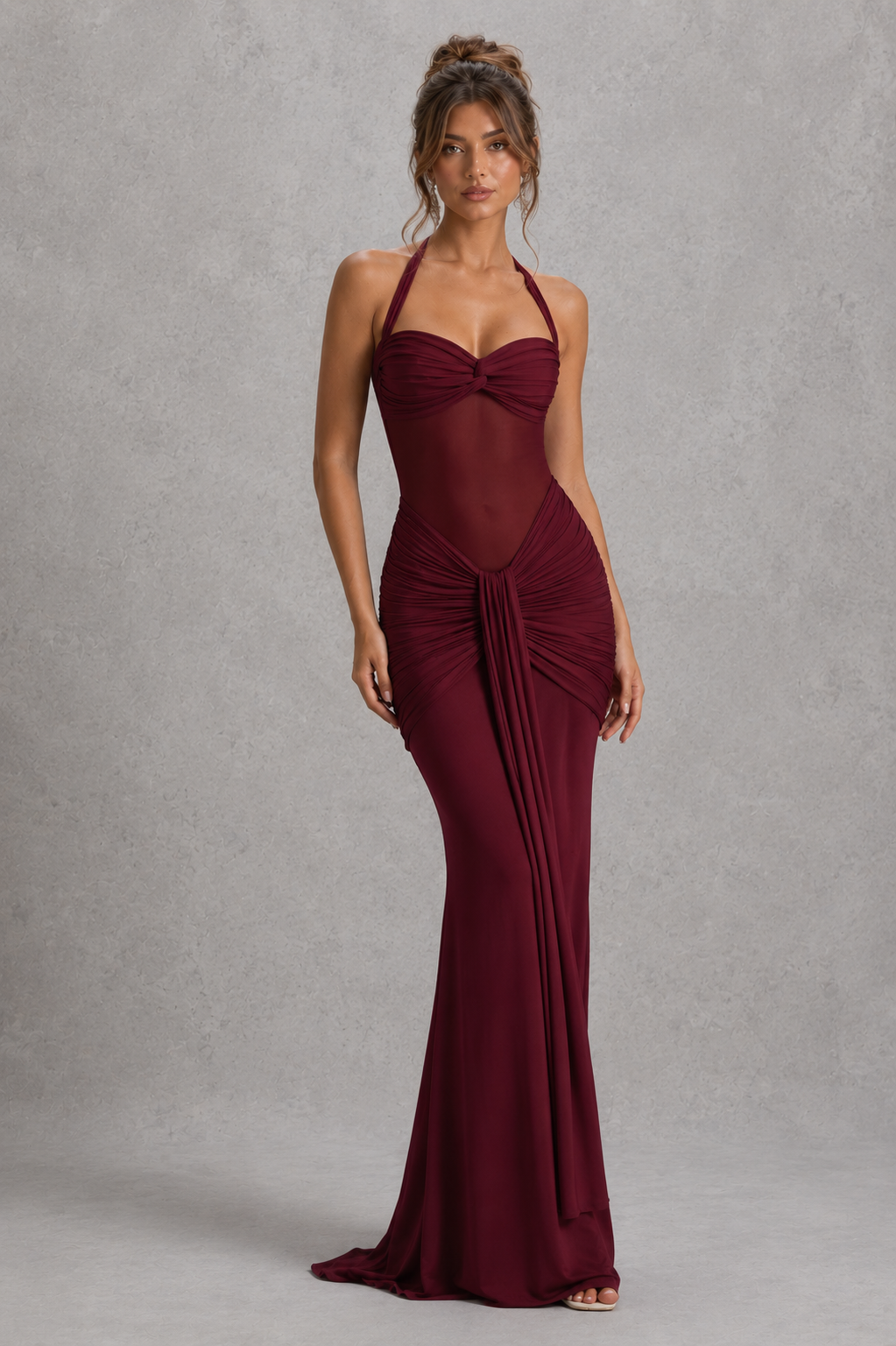 Woman wearing a burgundy evening gown against a gray background
