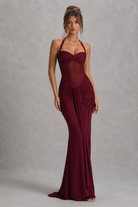 Woman wearing a burgundy evening gown against a gray background