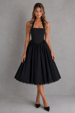 Woman wearing a black halter neck dress against a gray background