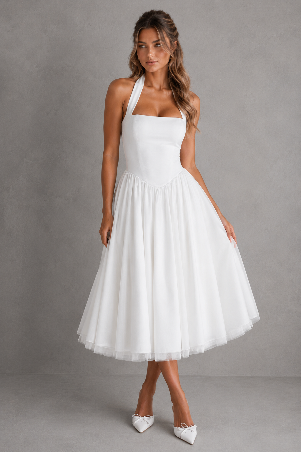 Woman wearing a white halter neck dress against a gray background