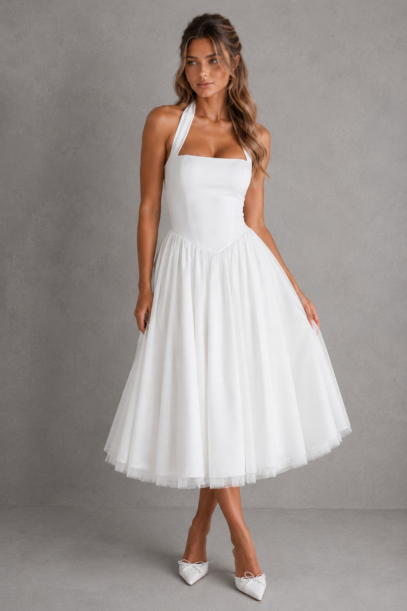 Woman wearing a white halter neck dress against a gray background