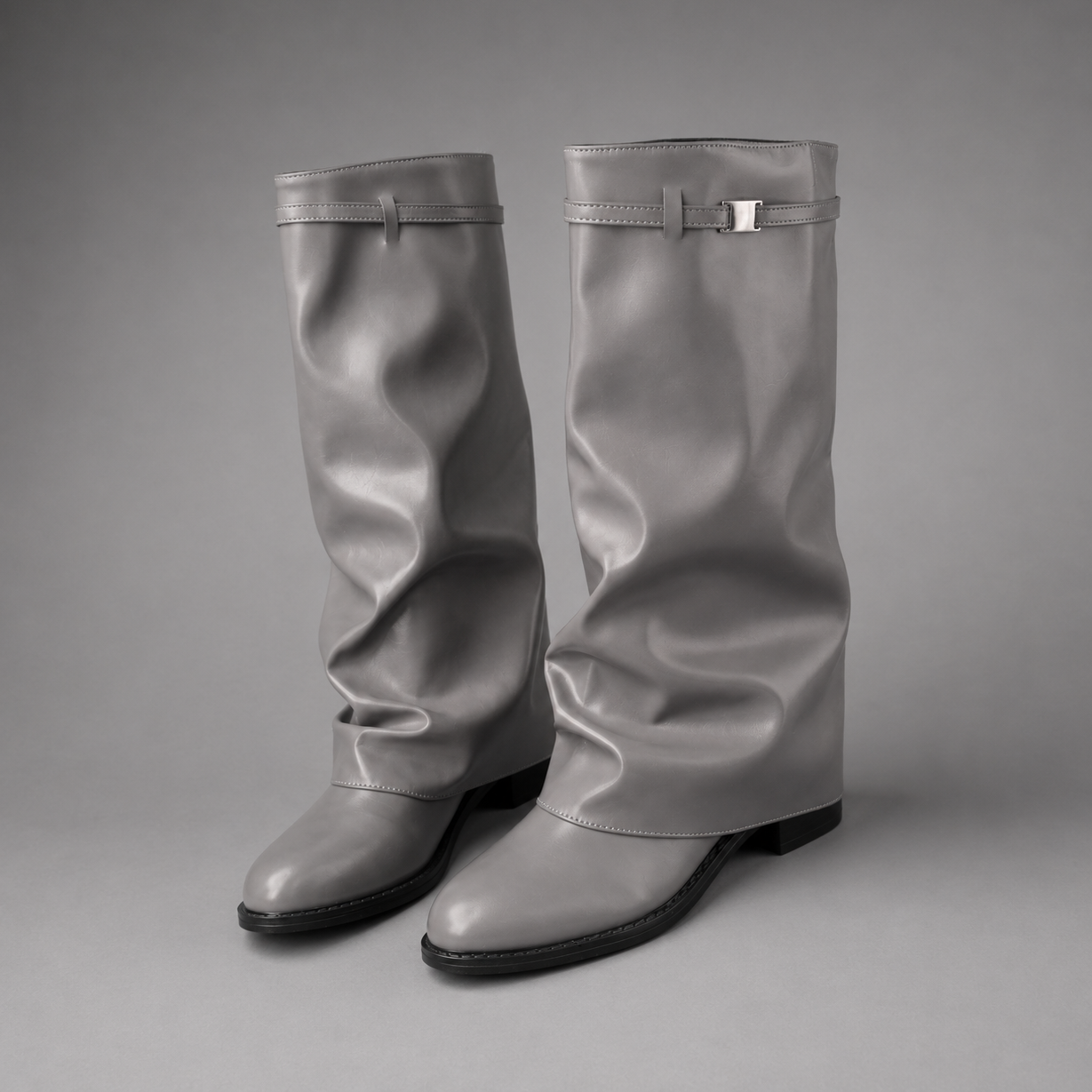 Women’s knee-high slouch boots with pointed toe, low block heel and metal cuff detail.