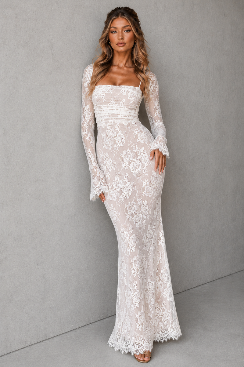 Woman wearing a white lace dress against a gray background