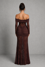 Woman wearing a brown off-shoulder evening gown with long sleeves on a gray background