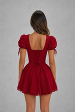 Red dress with puff sleeves and lace-up back on a gray background