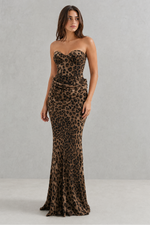 Woman wearing a strapless leopard print gown against a gray background