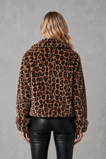 Women's leopard print faux fur cropped jacket with long sleeves, relaxed fit and soft plush texture, styled as a warm and lightweight winter coat.