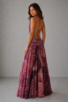 Woman wearing a patterned dress with a plain background
