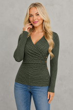 Woman wearing a purple ribbed sweater and blue jeans against a white background