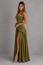 Woman wearing a green dress with a slit on a gray background
