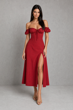 Woman wearing a red off-shoulder dress with a slit on a gray background