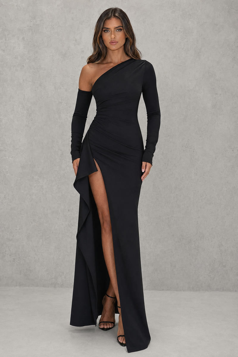 Woman wearing a black one-shoulder dress with a slit on a gray background