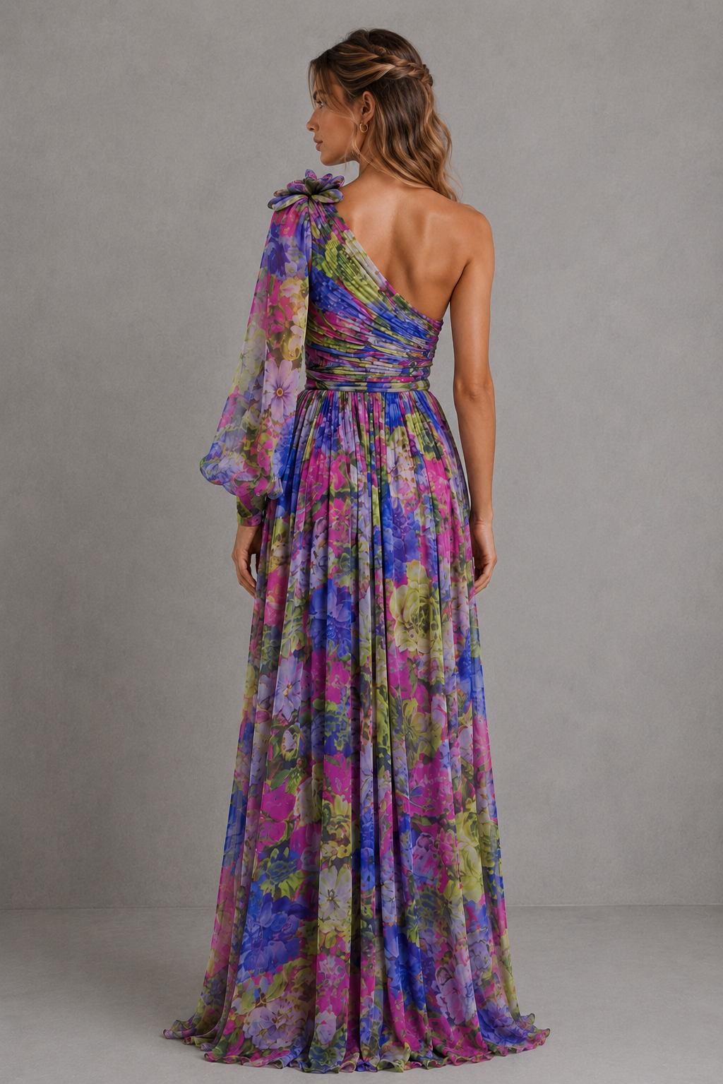 Woman wearing a colorful one-shoulder dress against a gray background