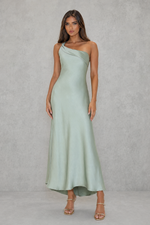 Woman wearing a light green one-shoulder dress against a plain background