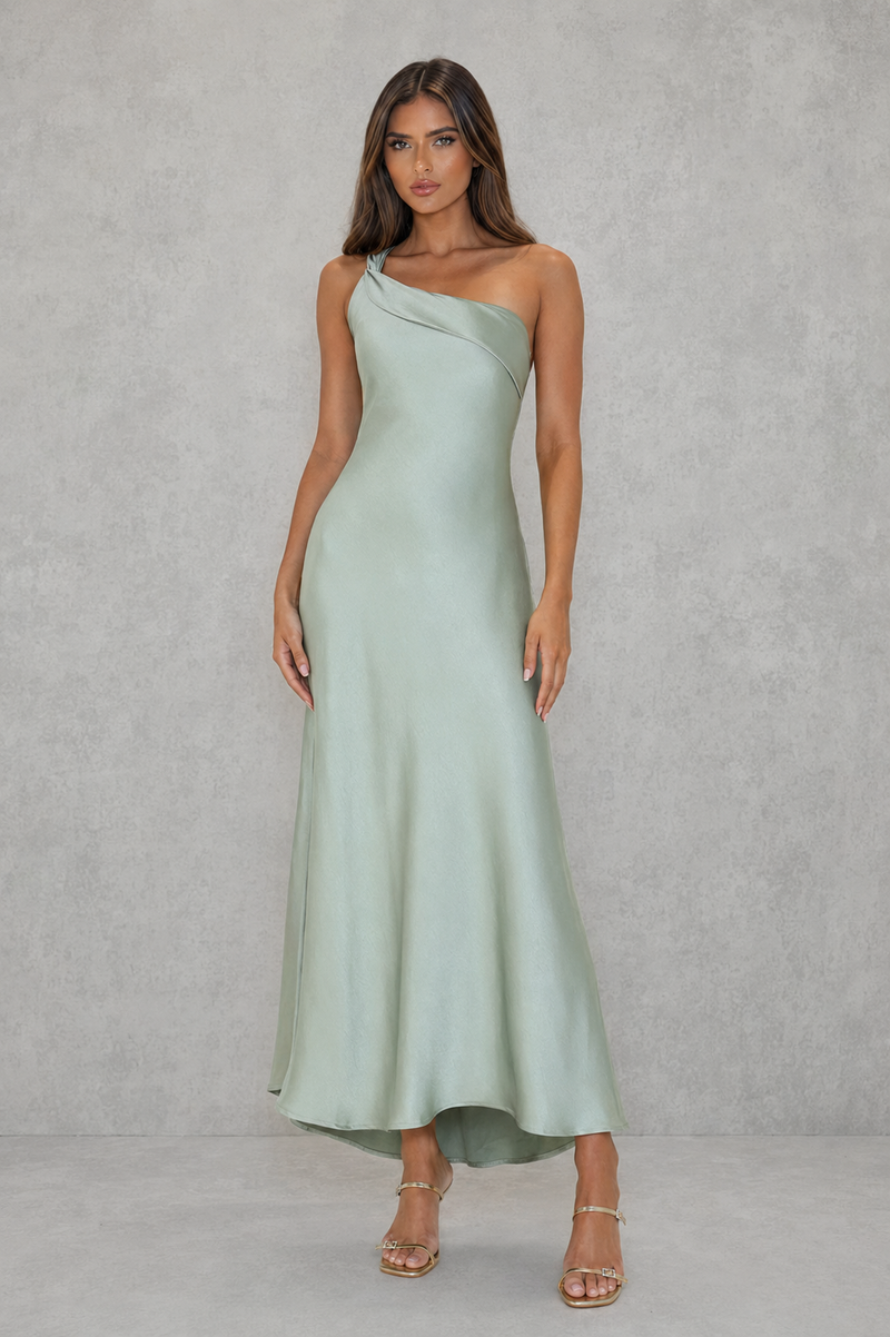 Woman wearing a light green one-shoulder dress against a plain background