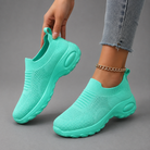Women's orthopaedic slip-on trainers with a breathable stretch-knit upper, chunky cushioned sole and lightweight design, offering all-day comfort for walking, commuting, travel and everyday casual wear.