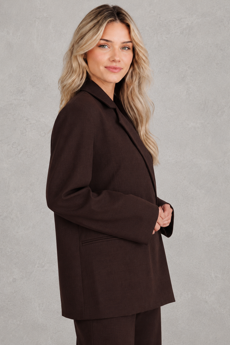 Women's oversized asymmetrical blazer with a relaxed fit, structured shoulder pads, asymmetrical front button fastening and side slits, ideal for smart-casual workwear and everyday layering.