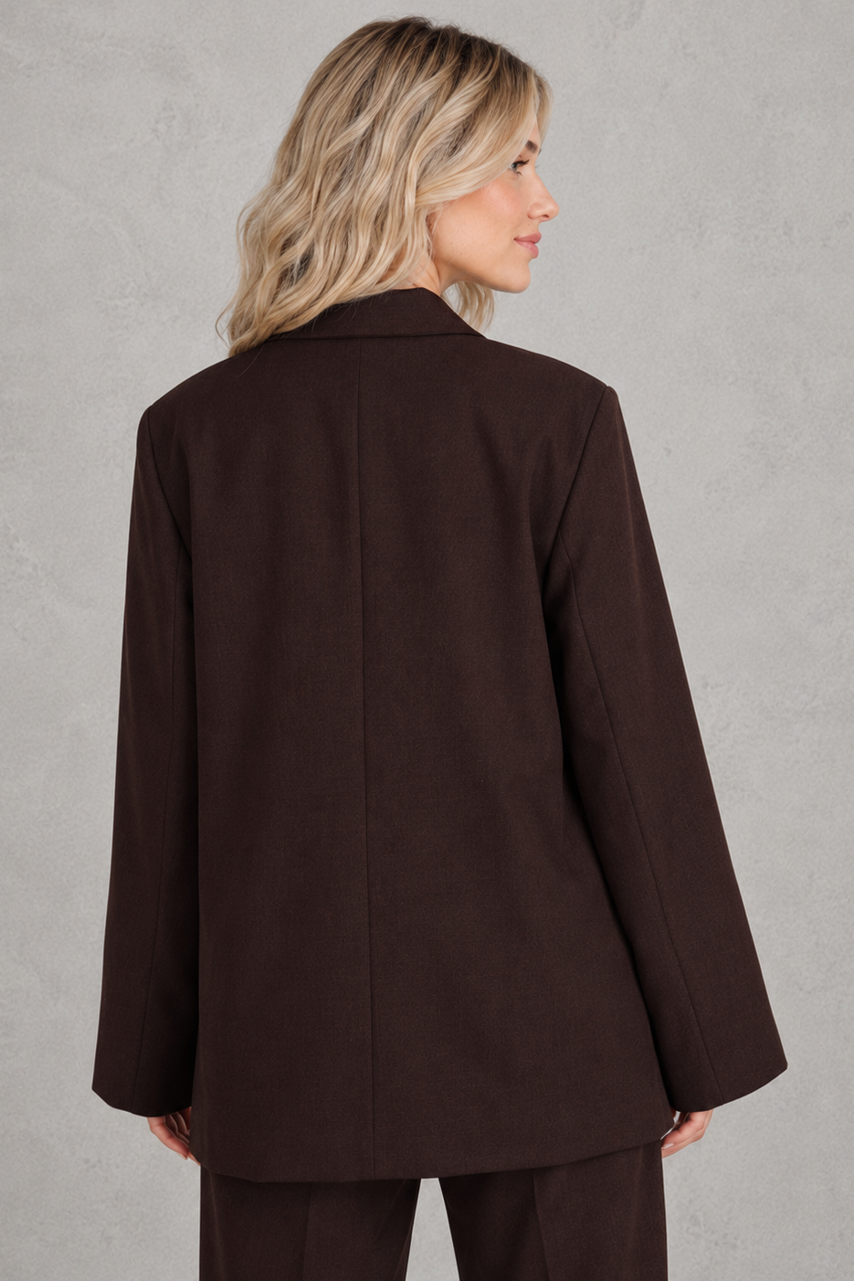 Women's oversized asymmetrical blazer with a relaxed fit, structured shoulder pads, asymmetrical front button fastening and side slits, ideal for smart-casual workwear and everyday layering.
