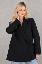 Women's oversized asymmetrical blazer with a relaxed fit, structured shoulder pads, asymmetrical front button fastening and side slits, ideal for smart-casual workwear and everyday layering.
