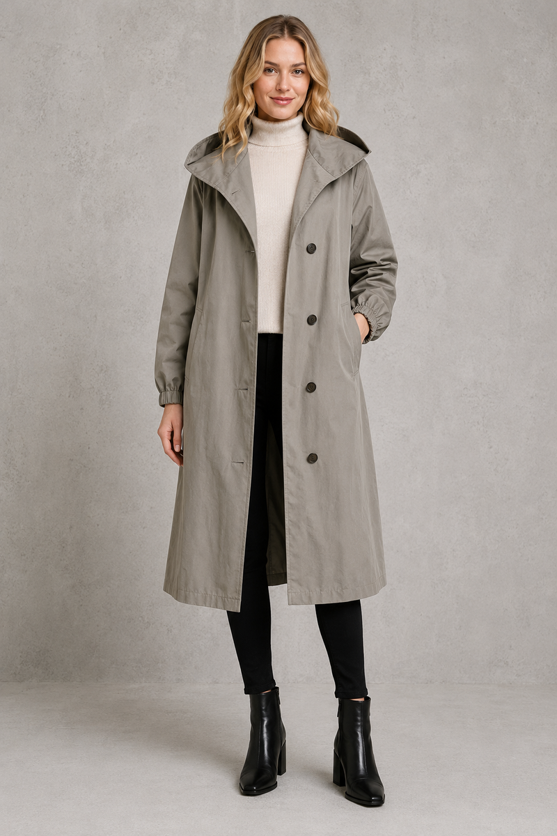 Women's oversized waterproof trench coat with a longline silhouette, adjustable drawstring hood, elasticated cuffs and lightweight water-repellent fabric, ideal for rainy weather and everyday wear.