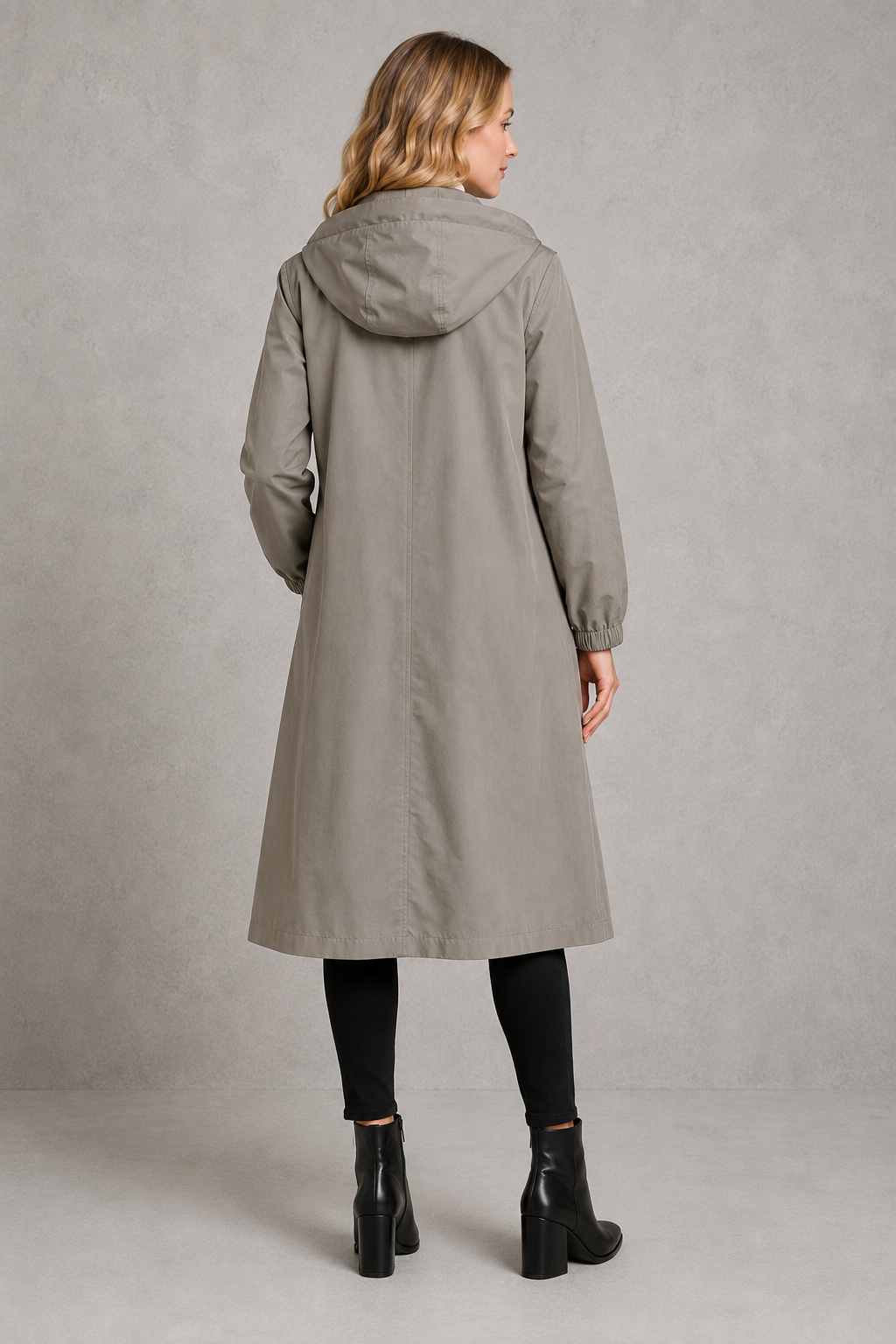 Women's oversized waterproof trench coat with a longline silhouette, adjustable drawstring hood, elasticated cuffs and lightweight water-repellent fabric, ideal for rainy weather and everyday wear.