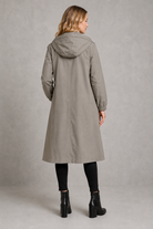 Women's oversized waterproof trench coat with a longline silhouette, adjustable drawstring hood, elasticated cuffs and lightweight water-repellent fabric, ideal for rainy weather and everyday wear.