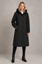 Women's oversized waterproof trench coat with a longline silhouette, adjustable drawstring hood, elasticated cuffs and lightweight water-repellent fabric, ideal for rainy weather and everyday wear.