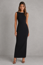 Woman wearing a black sleeveless dress against a gray background