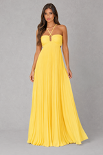 A woman modeling a bright yellow strapless maxi dress with a sweetheart neckline, thin crisscross halter straps, and a pleated skirt, set against a neutral gray studio background.